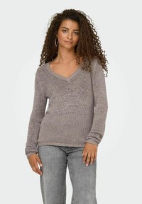 Pull tricoté gris clair avec un col en V, des manches longues et des poignets côtelés, présentant un motif texturé et une coupe décontractée.