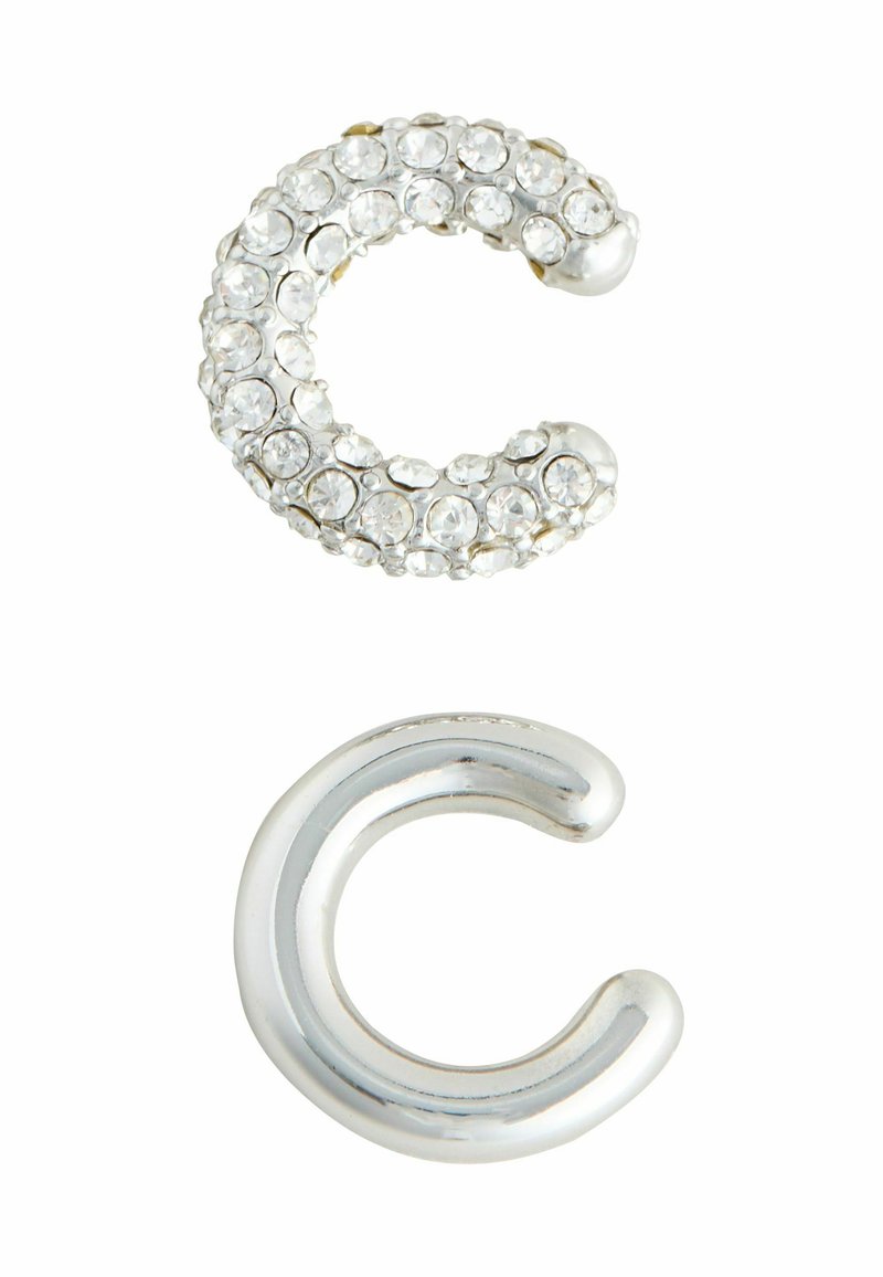 Rhinestone-beklædt sølv 'C' form ovenpå; poleret sølv 'C' form nedenunder. Begge genstande har glatte overflader og rundede ender.