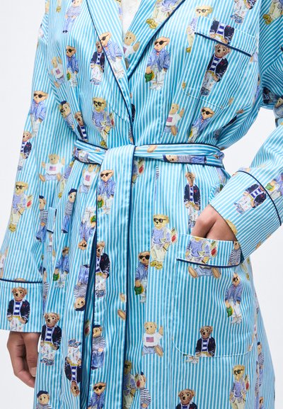 Ρόμπα ανοιχτού γαλάζιου με ρίγες και ζώνη, διακοσμημένη με διάφορες αρκουδάκια ντυμένες με καθημερινά ρούχα και γυαλιά ηλίου.