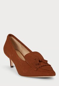 Barna velúr magassarkú cipő, hegyes orral, díszes bojtokkal és kis törékeny sarokkal, sima bélésborítással és texturált külső felülettel.