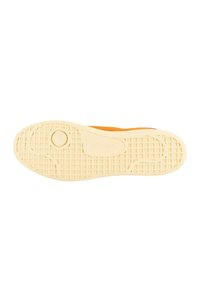 Sola in gomma di una sneaker, caratterizzata da un motivo a griglia testurizzato di colore crema con un accento logo rotondo vicino al centro.