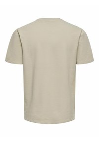 Beige tekstureret t-shirt med rund hals og korte ærmer. Stoffet har et subtilt vaffelmønster.