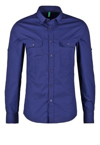 Marinblå långärmad skjorta i bomull. Har en knappad krage, två bröstfickor och knäppning vid ärmslut. Slät textur.