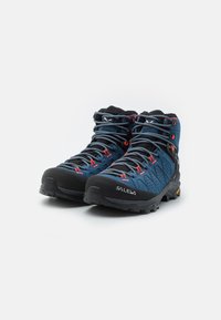 Blå vandrestøvler med overdel i mesh og gummi, sort gummitåhette, grå snørebånd og røde detaljer. Vibram sål for godt greb.