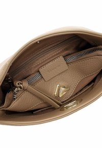 Beige leather handbag interior with a zippered pocket, a smaller zippered pouch featuring gold triangular hardware, and fabric lining.