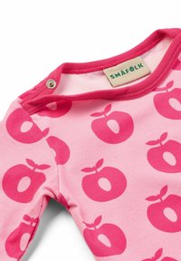 Mono de manga larga rosa con grandes patrones de manzanas rojas y botón a presión en el cuello. Hecho de suave tela de algodón.