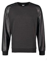 Sort sweatshirts med lange ærmer, lavet af glat læder på skuldrene. Kroppen er af blødt stof med en ribstrikket kant og manchetter.
