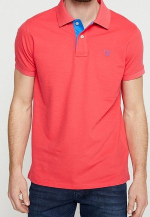 Coral polo shirt with short sleeves, a blue collar, and a small logo on the chest. Made from cotton with a smooth texture.