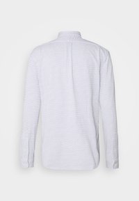 Bílé dlouhé rukávy s malým černým diamantovým vzorem, zapínací manžety a skladem uprostřed zad.