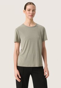 T-shirt verde chiaro a maniche corte con scollatura rotonda, realizzato in tessuto morbido, caratterizzato da una vestibilità rilassata e dettagli di cucitura minimi.