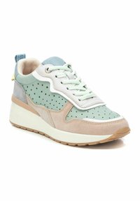 Zapatilla verde y beige con parte superior perforada, superposiciones blancas y acentos texturizados. Presenta una suela clara y diseño de cordones.