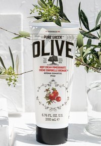 Biała tubka kremu do ciała z czarnym napisem, z ilustracją granatu, czarną zakrętką i informacjami o naturalnych składnikach. 200 mL.