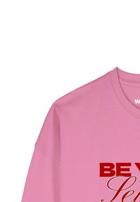 Roze sweatshirt met een ronde hals, voorzien van grote rode tekst "BE YOURSELF" in een decoratief lettertype. Gladde stof met een comfortabele pasvorm.