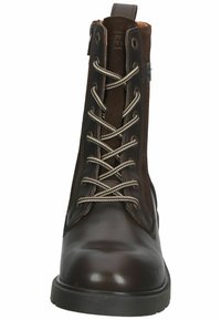 Bottine en cuir marron avec tige en daim marron, lacets contrastants et bout rond. Dispose d'une fermeture éclair et d'une semelle texturée pour une meilleure adhérence.