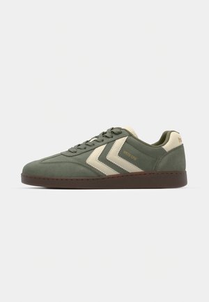 Grøn ruskinds sneakers med cremefarvede detaljer og retro-inspireret chevron-design. Har en rund tå og tekstureret brungummisål.