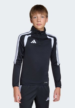 Musta urheilutoppi korkealla kauluksella, jossa valkoiset raidat hihoissa ja Adidas-logo rinnassa. Kosteutta siirtävä kangas.