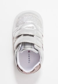 Silberne synthetische Kleinkinderschuhe mit glitzernden Akzenten, doppelten Klettverschlüssen, abgerundeter Spitze und einem gepolsterten Innenraum mit einem Markenlabel.
