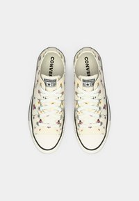 Off-white Converse All Star sneakers with floral print, white laces, black trim, and "Converse All Star" logo on tongues.