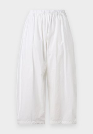 Bílé volné kalhoty s elastickým pasem. Vyrobené z lehkého materiálu s hladkou texturou. Zkrácená délka a žádné viditelné zapínání.