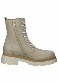 Botas de tobillo de cuero beige con una suela blanca gruesa, que cuentan con cordones y una cremallera lateral para mayor facilidad al ponerlas. Los acentos de costura completan el diseño.