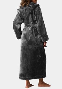 Lång, huvad grå badrock i mjukt, plyschigt tyg. Har vida ärmar, ett knytbälte och en något strukturerad yta.