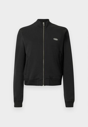 Chaqueta negra con cierre de cremallera y diseño ajustado, cuello y puños acanalados, con un pequeño logotipo en el pecho izquierdo. Textura de tela lisa.