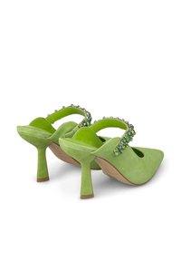 Escarpins en suède vert avec un bout pointu, design à bride arrière, accentués de décorations vertes et translucides sur la sangle.
