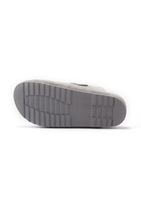 Suola grigia delle scarpe con un motivo di grip in gomma testurizzata, bordi sagomati e un tacco piatto. Materiale simile alla pelle scamosciata sulla superficie superiore.