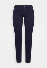 Pantalones ajustados de un azul marino oscuro con cierre frontal de botón y cremallera, y diseño de cinco bolsillos, dispuestos sobre un fondo blanco.