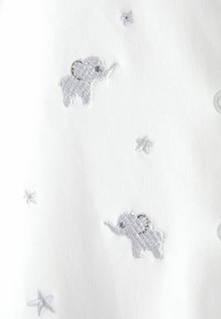 Țesătură albă cu elefanți brodați gri și stele mici. Elefanții sunt conturați cu cusături gri deschis, adăugând textură designului.