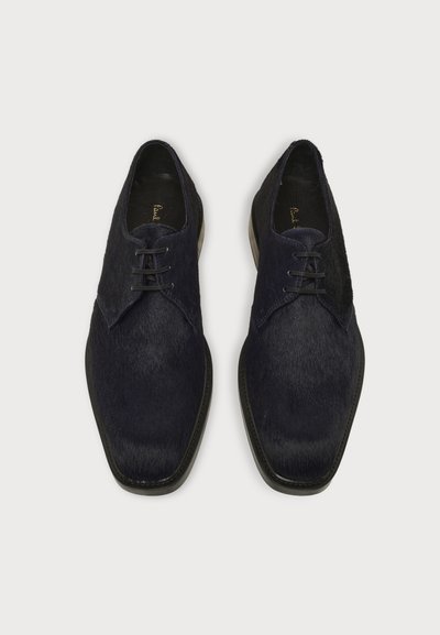 Paire de chaussures habillées en cuir noir à lacets avec un bout carré légèrement pointu, vues de dessus sur un fond clair uni.