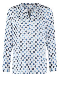 Blusa a maniche lunghe in tessuto bianco con motivo a pois blu. Presenta una chiusura con bottoni e una vestibilità morbida con dettagli arricciati sulle spalle.