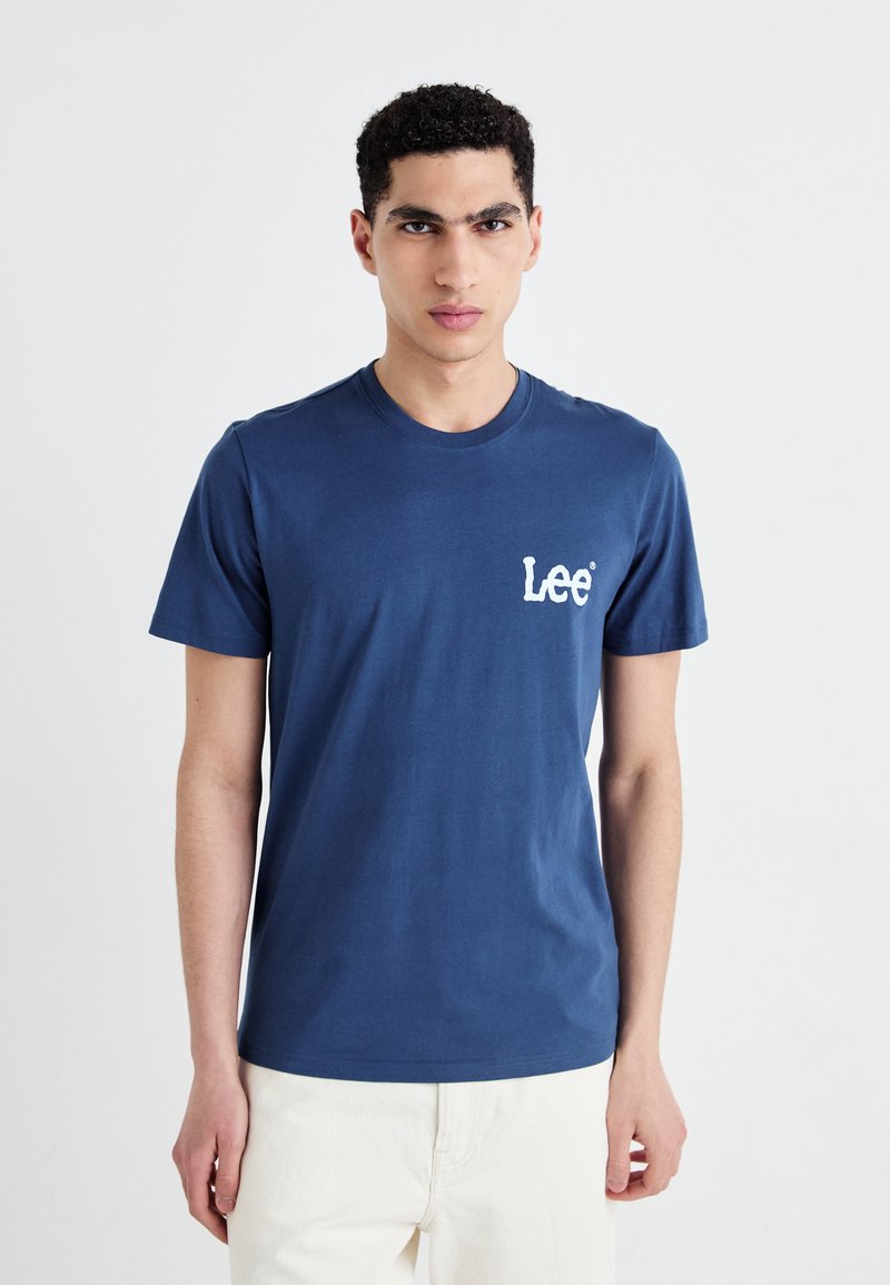 Tricou din bumbac bleu marin, cu mâneci scurte, decolteu rotund și logo-ul alb "Lee" imprimat în zona din stânga a pieptului. Textură netedă.
