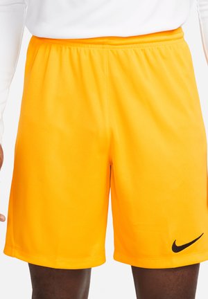 Herren Sportshorts, leuchtend orangefarbener Stoff, elastischer Bund, schwarzes Nike-Logo an der unteren linken Seite, glatte Textur, knielanger Schnitt.