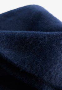 Mørk navy uldstof med en blød, struktureret overflade, der har synlige fibre og en glat fald. Tæt og varm, ideel til yderjakker.