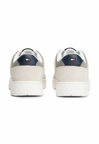 Sneaker in suede grigio con suola in gomma bianca, dettagli in rete blu navy e una piccola etichetta del logo sul tallone. Design semplice e a profilo basso.
