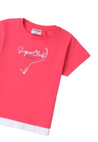 Camiseta de manga corta rosa hecha de algodón. Presenta un texto bordado blanco "SuperClub" y detalles azules cerca del dobladillo.