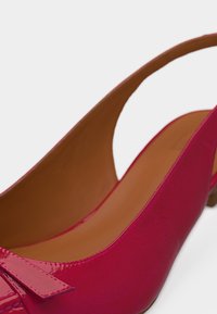 Κόκκινο γυαλιστερό δερμάτινο παπούτσι slingback με χαμηλό τακούνι και διακοσμητικό φιόγκο στο μπροστινό μέρος, εσωτερική επένδυση σε ταμπά χρώμα.