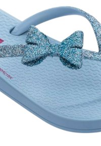 Flip-flop azzurro chiaro con suola texturizzata, accentata da un fiocco blu glitterato e una sottile tracolla. Design semplice senza ulteriori motivi.