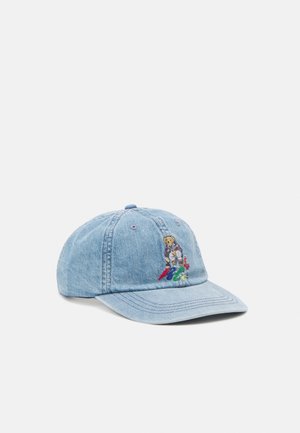 Casquette de baseball en jean bleu clair avec un ours en peluche brodé assis sur des lettres colorées à l'avant gauche.