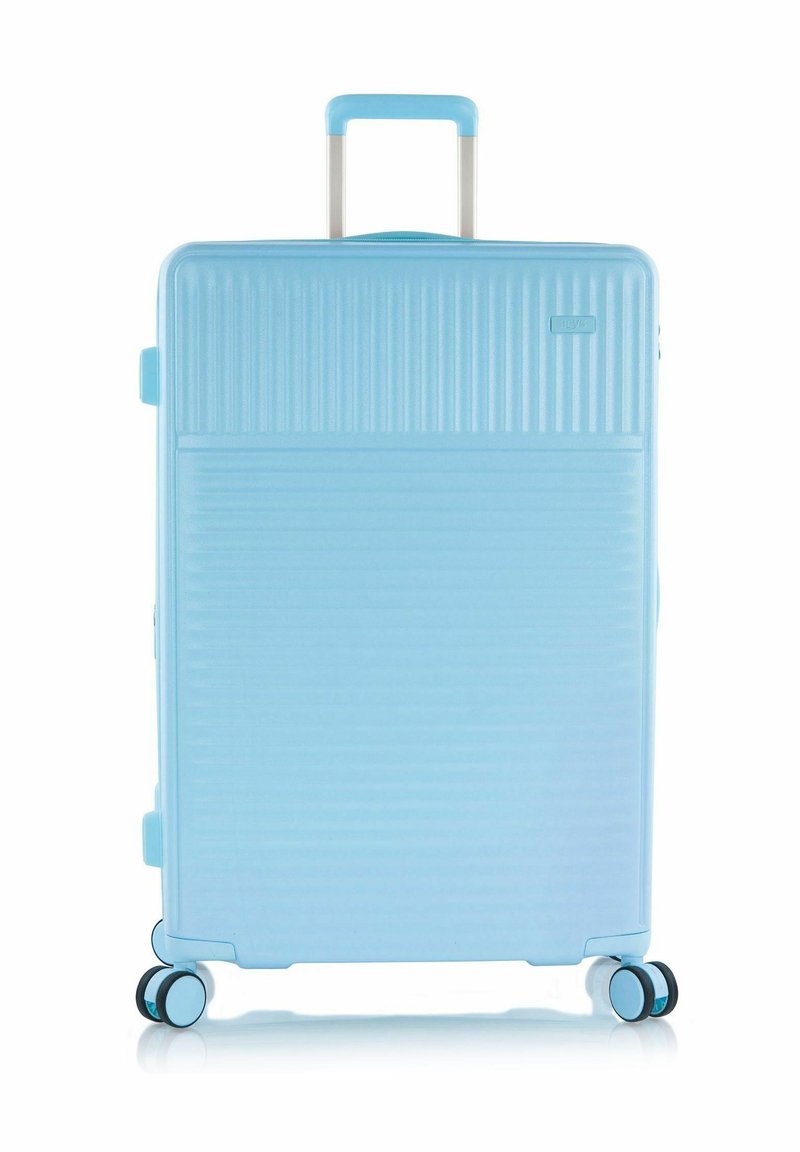 Lichtblauwe harde koffer met een telescopische handgreep en vier dubbele spinnerwielen die rechtop staan.