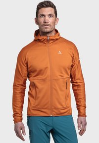 Felpa con zip arancione con un motivo testurizzato, cappuccio e due tasche frontali; abbinata a pantaloni turchesi. Presenta il logo del marchio sul petto.