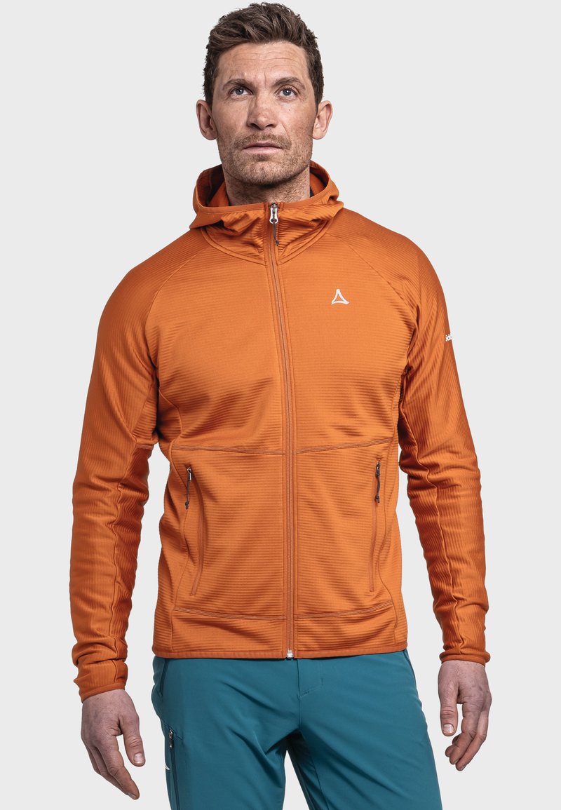 Pomarańczowa bluza zip-up z teksturowanym wzorem, kapturem i dwiema przednimi kieszeniami; zestawiona z turkusowymi spodniami. Zawiera logo marki na klatce piersiowej.
