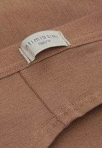 Bruine stof met een gladde textuur, voorzien van een crèmekleurig label waarop "intimissimi Natural" staat. Eenvoudig ontwerp zonder patronen.