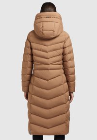 Mantou lung de culoare caramel, umplut, cu un design în formă de zigzag, având o glugă mare și buzunare laterale, fabricat din material rezistent la apă.