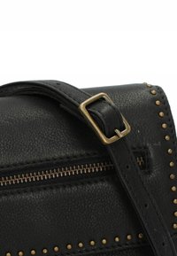 Borsa in pelle nera con superficie texturizzata, dettagli in hardware di ottone, zip esposta e borchie dorate lungo il bordo.