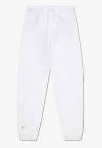 Bijele hlače za trčanje koje upijaju vlagu s elastičnim pojasom, patentnim zatvaračima na manžetama, i logotipom "Ultra Dry" na donjem dijelu lijeve nogavice. Glatka tekstura.