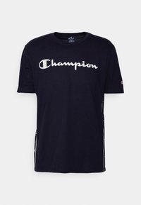 Námorně modré bavlněné tričko s krátkým rukávem. Na hrudi má bílé logo "Champion" a kontrastní boční pruhy.