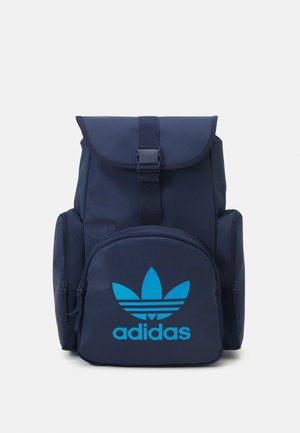 Zaino Adidas blu navy con patta anteriore a fibbia, ampia tasca con cerniera con logo turchese e compartimenti laterali con cerniera.