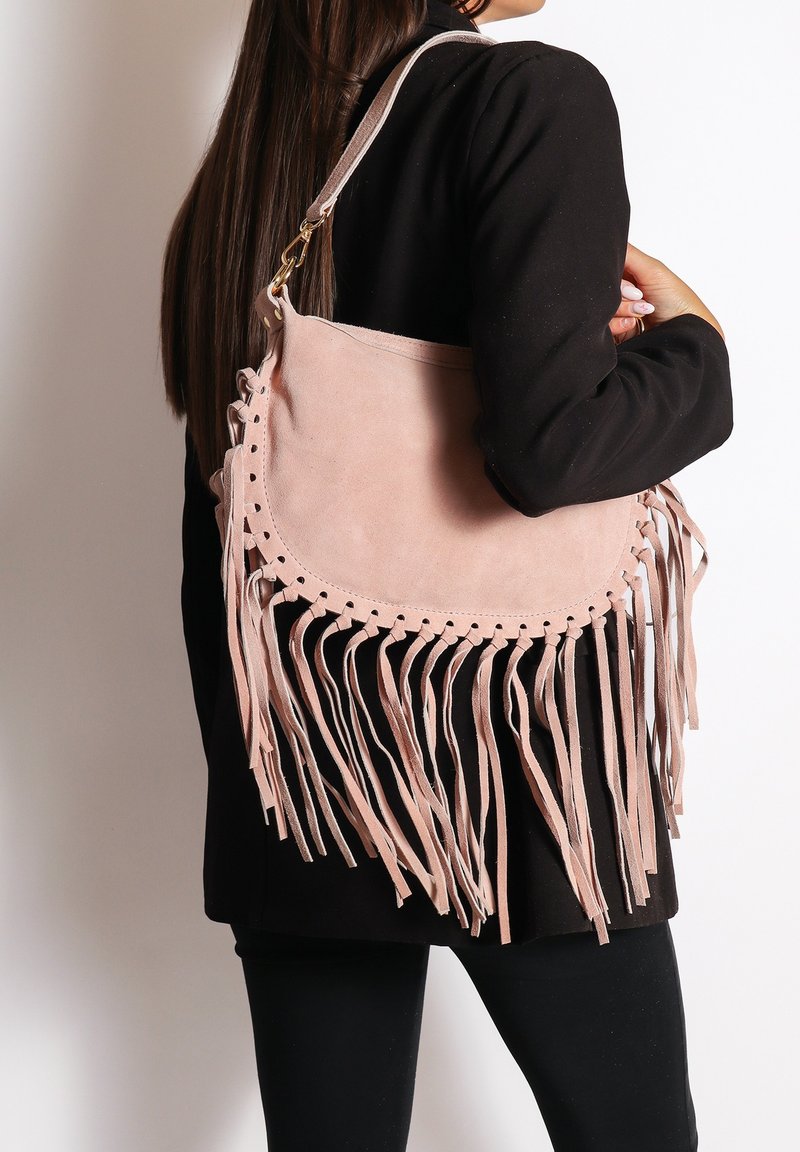 Roze suède schoudertas met franjes en kantaccenten, met een ronde vorm en een enkele schouderriem.